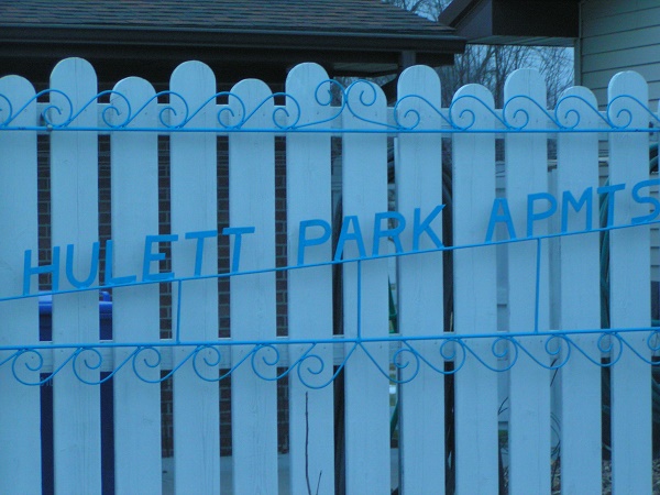 Huelett Park Apartments Sign and White Fence